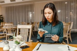 (woman reading the bill at a restaurant)